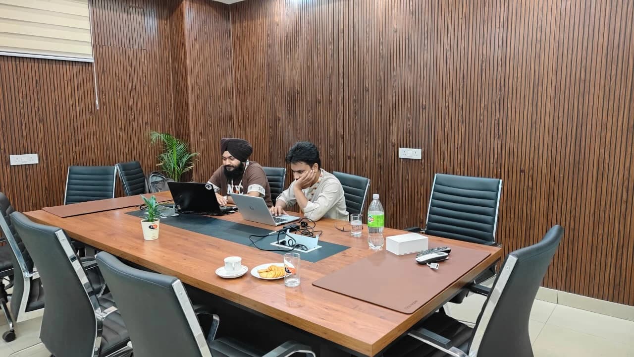 Two Algorizz engineers working on laptops at a conference table during the LoomOS deployment